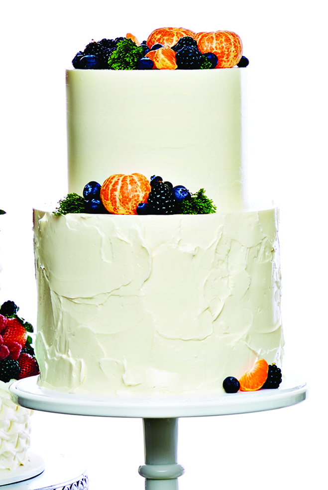 A buttercream tiered cake with clementines, blueberries and blackberries from Farina Baking Co.