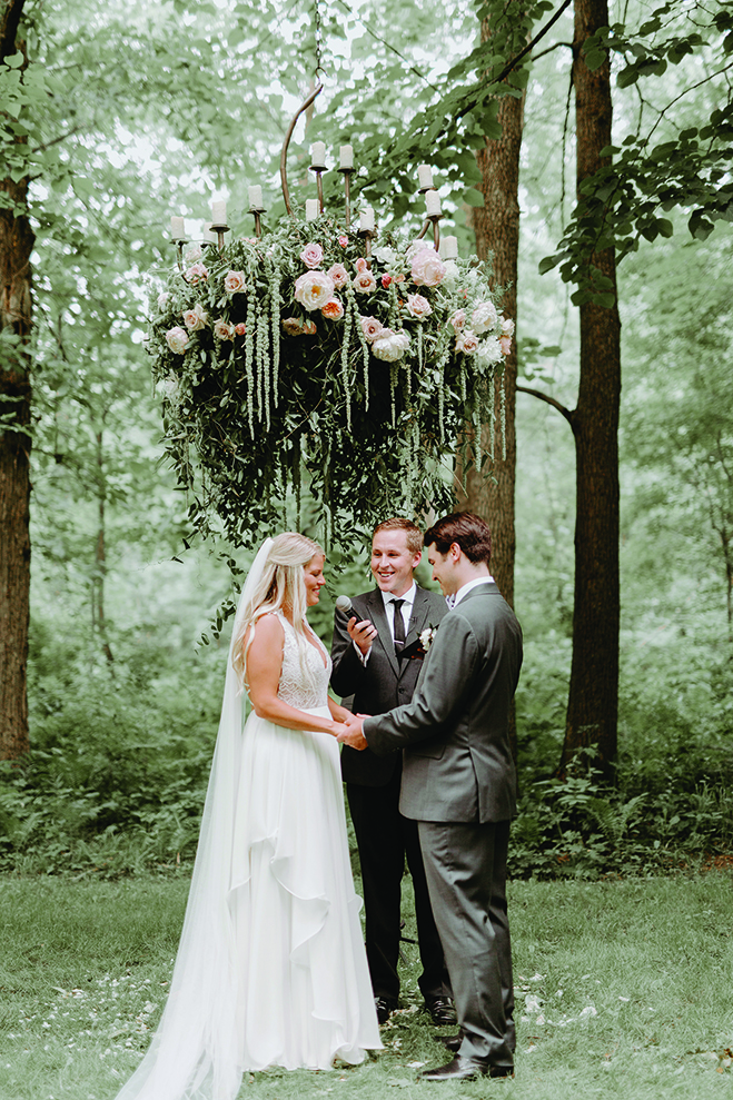 Kate and Lucas stand before their officiant during their wedding ceremony at Creekside Farm Weddings & Events