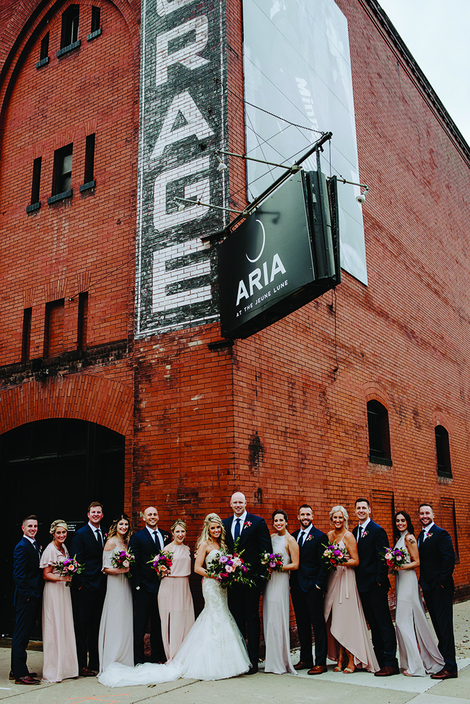 Molly and Seth pose with their wedding party in front of Aria.