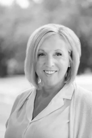 Black and white portrait of Mary Hotaling, Sales Manager at Ocotillo Golf Club, smiling warmly in an outdoor setting. With extensive experience in hospitality and event planning, Mary specializes in creating seamless and unforgettable wedding experiences at one of Arizona’s most scenic golf course venues.