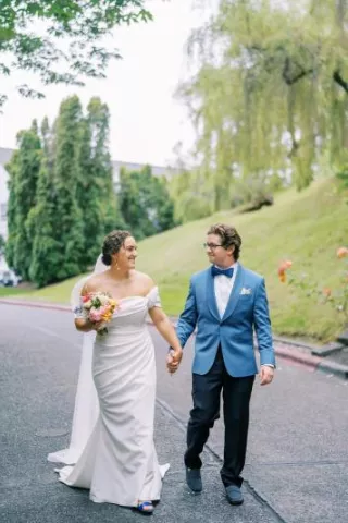 Bride and groom hold hands walking together on their wedding day at Teh Admiral's House