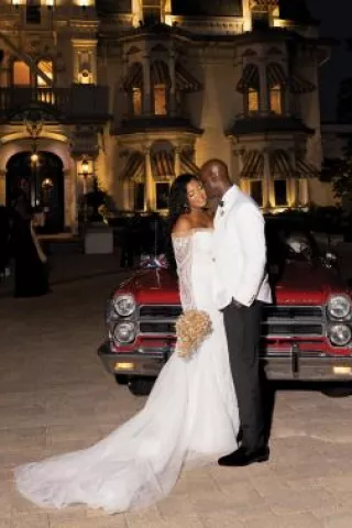 Marcelia and Renwick pose in front of vintage car outside of the Wisconsin Club