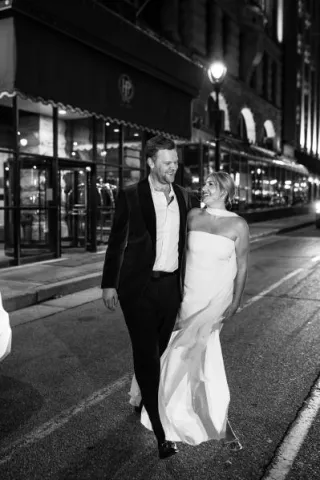 Couple walking out in the street outside of The Pfister Hotel, the location of their welcome party