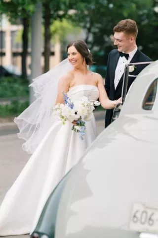 Meredith and Daniel enter their vintage getaway car in their wedding day attire