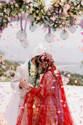 Bride and groom embrace under lush mandap at Malibu Seaview Estate