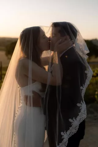 Bride and groom share a kiss on the grounds of Hearst Ranch Winery during golden hour