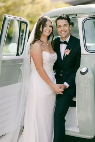Bride and groom pose next to retro truck in wedding day at Cavalli Estates