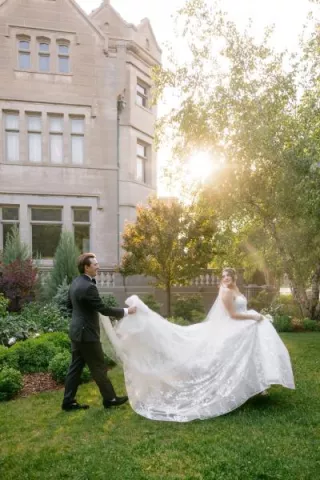 Jackson holds Grace's train as they walk across the grounds of American Swedish Institute