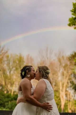 Couple shares a kiss under a rainbow
