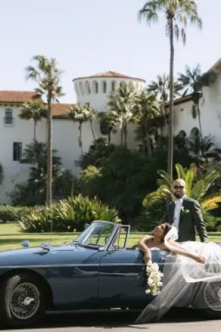Cristabel and Martin pose in their vintage getaway car outside of the Santa Barbara Courthouse