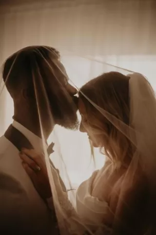 Groom kiss bride's forehead in close up shot in private wedding portrait session