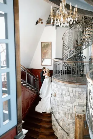 Lindsey and Scott pose on the staircase of Chateau de Harpe
