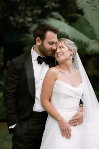 Sophie and Andrew pose side by side in their wedding attire