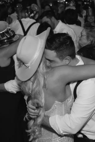 Bride and groom embrace in a hug, depicted in black and white