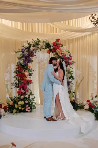 Danielle and Brandon share a kiss at the indoor floral altar