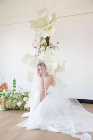 Model poses in front of hand crafted floral vignette 