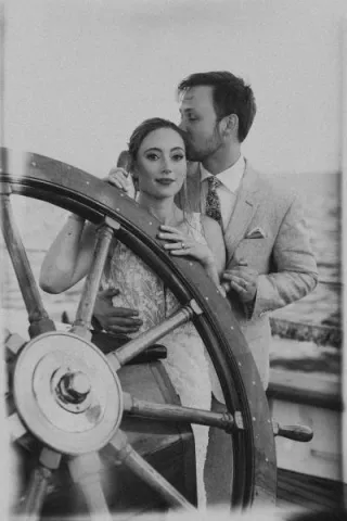 Kelsey and Gawan pose at the helm of Schooner Zodiac on their wedding day