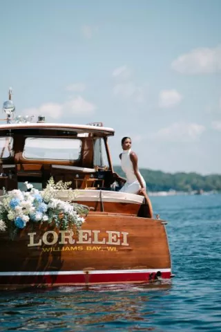 Model poses on a boat decorated in florals floating on Lake Geneva outside of The Abbey Resort
