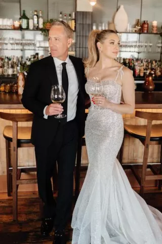 Kate and Tim pose with cocktails at the bar during their reception at Mara