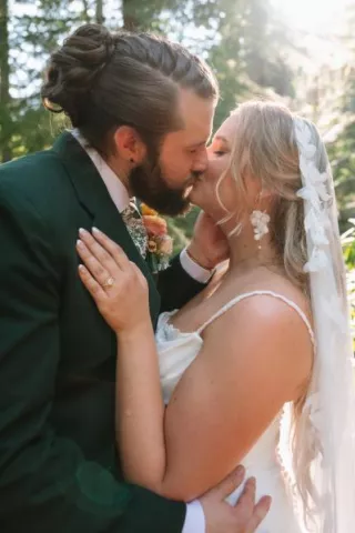 Natasha and Will share a kiss on their wooded wedding day