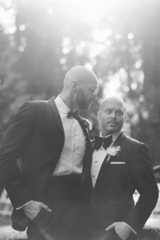 Zach and Bryce pose in their ceremony attire, in black and white
