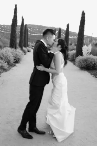 Stephanie and David Share a Kiss Outdoors at Wedding at Tre Posti
