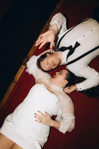 Lauren and Drew pose laying on the ground facing each other at Le Veneré