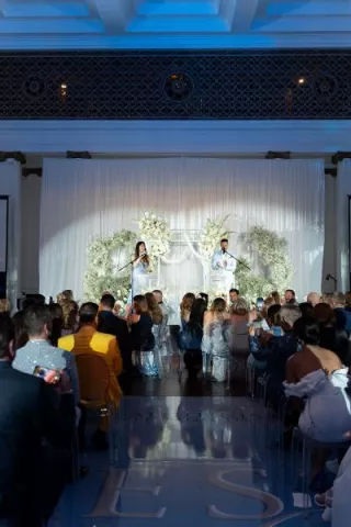 Guests seated at 440 Elm watching the California Wedding Day Best of 2025 ceremony hosted by Weddings Royale in front of a floral installation