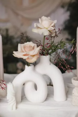 Sculptural stone vase holding two roses in imagined reception design