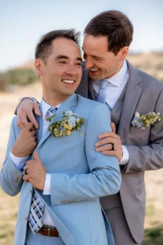 Jonathan and Robbie pose in a warm embrace on their wedding day