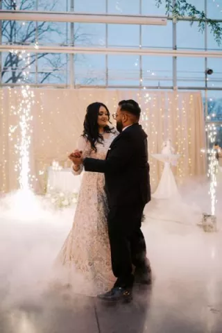 Bride and groom share their first dance accompanied by fog and cold sparks 