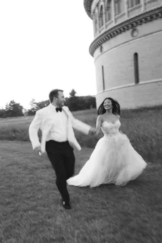 Bride and groom frolick through the grounds outside of Yerkes Observatory hand in hand on their wedding day