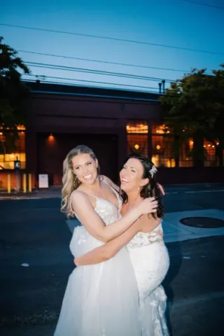Brides share an embrace outside of their wedding day at The Ruins