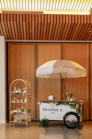 Spread of pastries and small bites next to a bubbly bar cart for spakrling wine