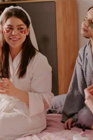 Bride and bridal party wearing robes and skincare eye masks during a relaxing wellness bachelorette party at home