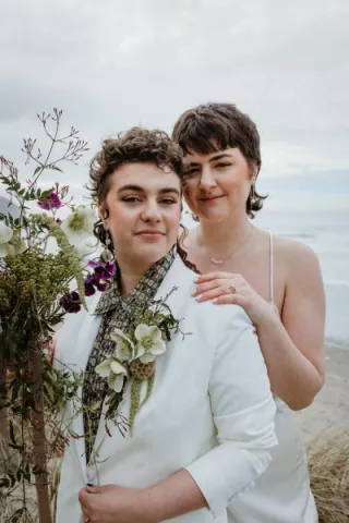 Close up of couple posing, one standing behind the other, in intimate elopement on Cannon Beach