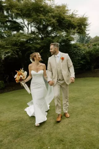 Sarah and Josh walk the grounds of the bride's childhood home on their lakeside wedding day