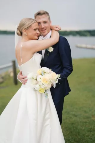 Grace and Lucas embrace with the lake in the background