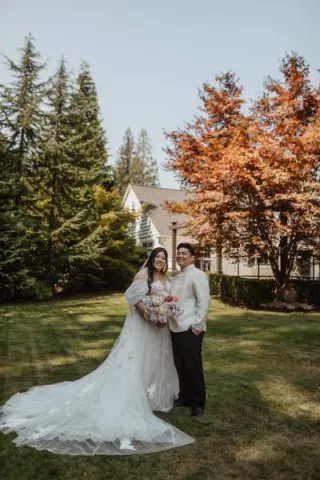 Bride and groom pose with bright foliage in the backdrop at Rock Creek Gardens