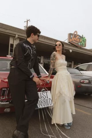 Bride and Groom pose outside of their restaurant wedding day 