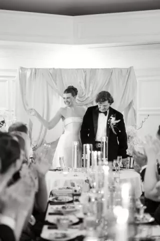Natalie and Trip laughing at the head table of their reception at St. Paul College Club 