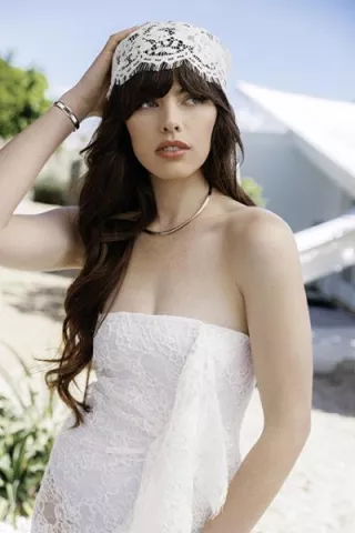 Model poses in strapless lace dress and trendy head wrap