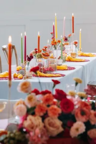 Vibrant tablescape featuring juicy hued florals, fruit accents and taper candles at Woodhaven