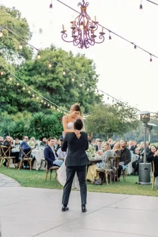 Dakoda and Colette Share a Sweet Moment During their First Dance Under Bulbed Lights at Charming Outdoor Affair at Temecula Creek Inn