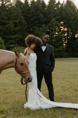 Models pose with a light brown horse on the grounds of Wind Mountain Ranch