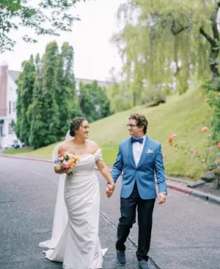 Bride and groom hold hands walking together on their wedding day at Teh Admiral's House