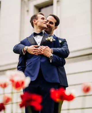 Zach and Clay Embrace Amidst the Flowers on their Wedding Day at The Madison Club