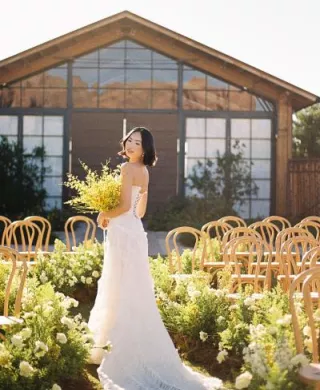 Model poses with yellow bouquet in hand in the middle of a wavy aisle in sunny editorial at the Paseo