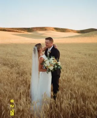 Abbey and Peter pose in golden fields of wheat on their wedding day