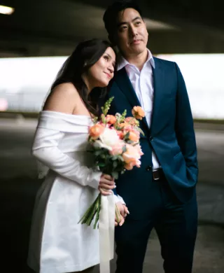 Bride Holding Bouquet and Resting Head on Husband's Shoulder